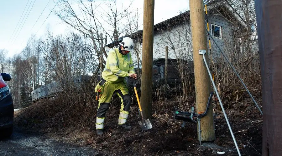 Arbeider som graver ved strømstolpe